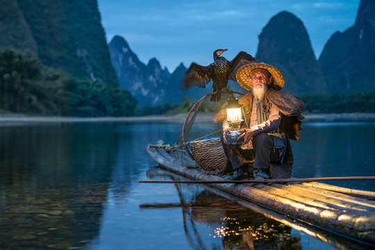 Traditional cormorant fisherman at night on the Li river, Guangxi, Yangshuo, China