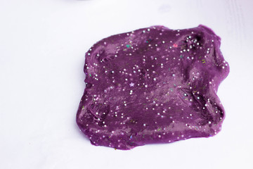 Fototapeta premium Children's creativity and motor development. Slime purple close-up on a white background in the form of a BLOB.