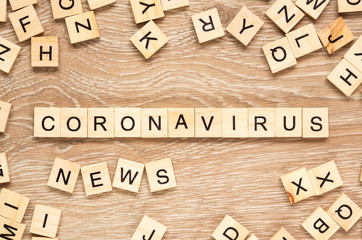The words "Coronavirus News" spelt out with letter tiles on the wooden background