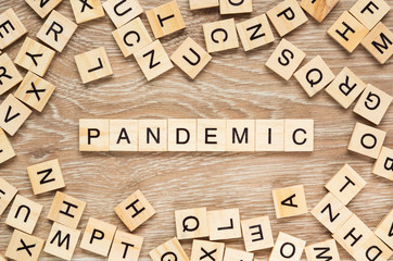 The word "Pandemic" spelt out with letter tiles on the wooden background