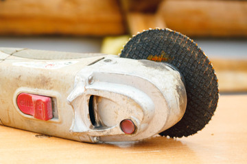angular sanding machine with a disk for grinding on a wooden table close-up