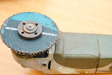 Plakat angular sanding machine with a disk for grinding on a wooden table close-up