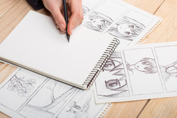 Artist drawing an anime comic book in a studio.