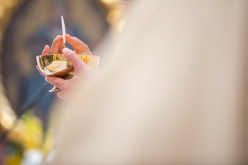 Priest' hands during a wedding ceremony/nuptial mass (shallow DOF; color toned image) - obrazy, fototapety, plakaty