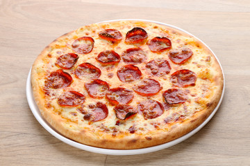 Pepperoni pizza with vegetables on a wooden background - super supreme pizza