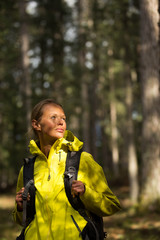 Pretty, young female hiker walking through a splendid old forest (shallow DOF)