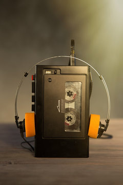 Old portable cassette player and headphones on a abstract background. Vintage advertisement style