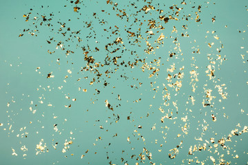 Golden flying sparkles on blue holiday background. Festive backdrop for your projects.