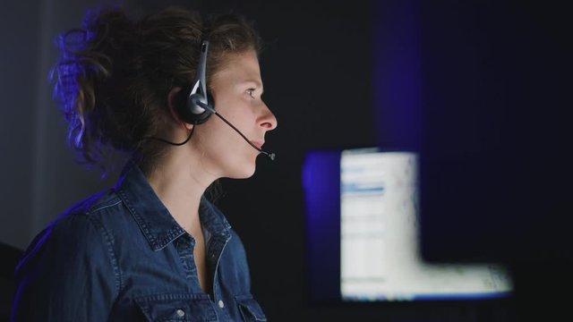 Low handheld view of female support technician focused on computer screens