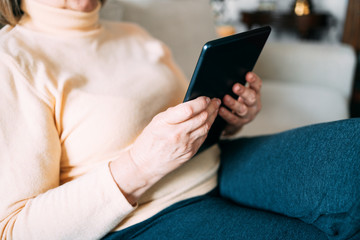 Old woman hands using a tablet. Old people with technology concept