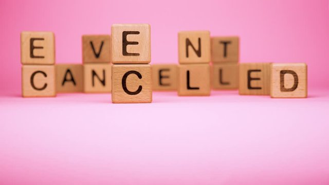 Event cancelled on wooden cubes. Cancelled word made with building blocks. Mass gathering cancelled. Repatriation and quarantine of travellers. Travel advice. Protect from coronavirus infection