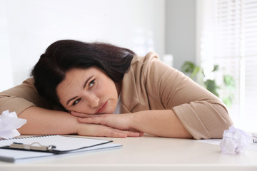 Lazy overweight worker at white desk in office
