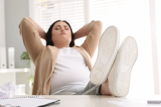 Lazy Overweight Worker With Feet On Desk In Office