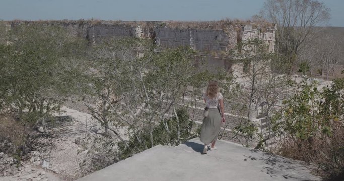 mujer observa ciudad de uxmal en la cima del templo mayor de uxmal.