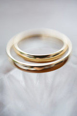 Obraz na płótnie Canvas Close-up view of two golden wedding rings. Wedding symbols, attributes. Holiday, celebration. Macro. Blur