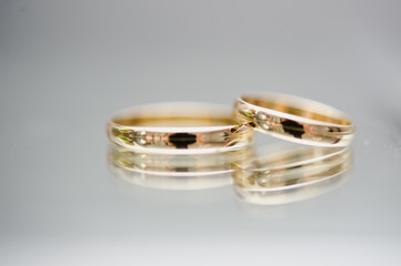 Close-up view of two golden wedding rings. Wedding symbols, attributes. Holiday, celebration. Macro. Blur