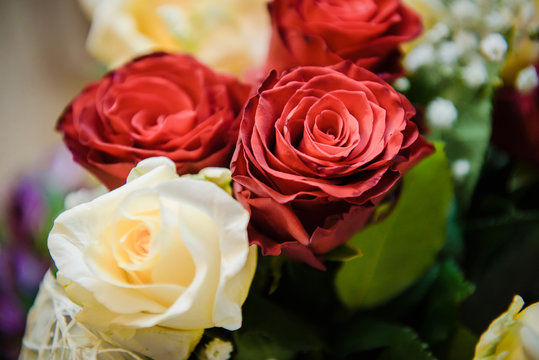 Fresh, lush bouquet of colorful flowers for present close-up photo. Wedding bouquet, red and yellow roses