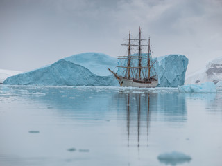 Fototapeta na wymiar sailing Expedition ship in antarctica surrounded by ice and ice