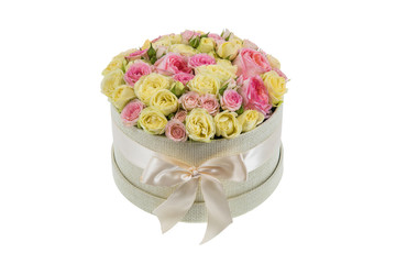 Fresh, lush bouquet of colorful flowers for present isolated on white background. Wedding bouquet of pink and yellow roses in the beige round gift box