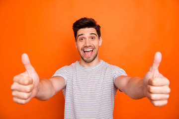 Closeup photo of crazy funny guy open mouth good news raise thumb fingers up approve express agreement wear casual striped t-shirt isolated bright orange color background