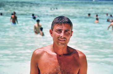 Happy male tourist visiting famous Maya Beach in Phi Phi Leh, Thailand