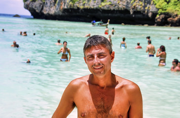 Happy male tourist visiting famous Maya Beach in Phi Phi Leh, Thailand