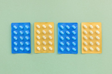 Set of various tablets in blister pack. Healthcare and medical concept. Close up, green background