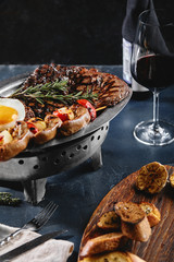 Grilled meat platter. Assorted delicious grilled meat with vegetables. Grilled mixed meat with pepper sauce and vegetables. Chef's hands spread meat on a plate