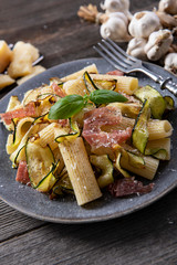 Tasty rigatoni pasta with courgette, prosciutto ham and grana padano cheese