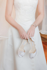 Wedding preparations. Bride`s morning. Beautiful young woman in luxurious white wedding dress with lace. Bride's hands with accurate manicure