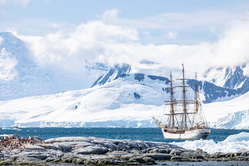 Fototapeta premium sailing Expedition ship in antarctica in front of the mountains surrounded by ice 
