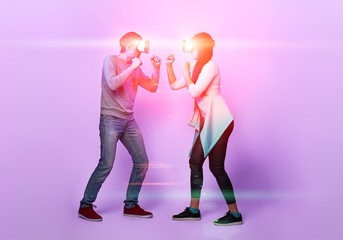 Naklejka premium Couple with virtual reality headset are playing game and fighting.