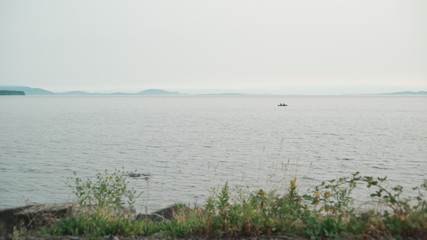 Horizon view of the ocean with a boat and mountains in White Rock British Columbia