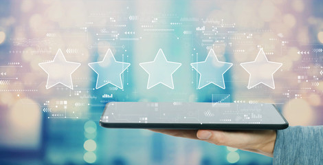 Rating star concept with man holding a tablet computer