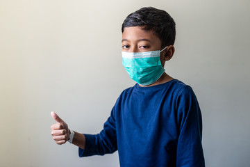 Happy Sick Muslim Kid with surgical mask. Precaution during Covid-19 Coronavirus scare