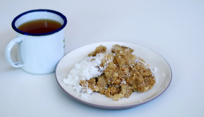 Tiwul and a cup of tea on white background. Tiwul is Indonesian traditional food. Made ​​from dried cassava (tapioca).               
