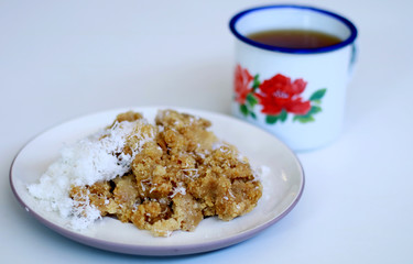 Tiwul and a cup of tea on white background. Tiwul is Indonesian traditional food. Made ​​from dried cassava (tapioca).               