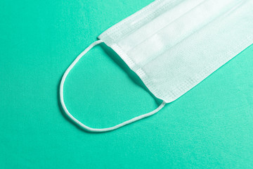 Surgical mask over minimalist green background
