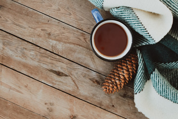 Flat lay winter and autumn cozy vintage background with copy space. The cup of tea or coffee on wooden table. Christmas atmosphere.