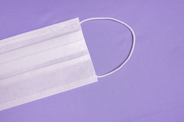 Surgical mask over minimalist purple background