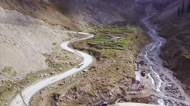 A bus going uphill in mountains of northern pakistan in naran valley going hunza via lulusar and babusar top - Aerial view drone shot 
