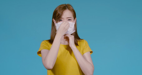 Young asian woman wearing mask protects filter and prevent infection on blue background,...