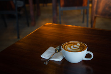 Digital tablet and cup of coffee on old wooden desk. / selective focus