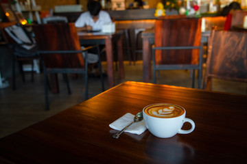 Digital tablet and cup of coffee on old wooden desk. / selective focus