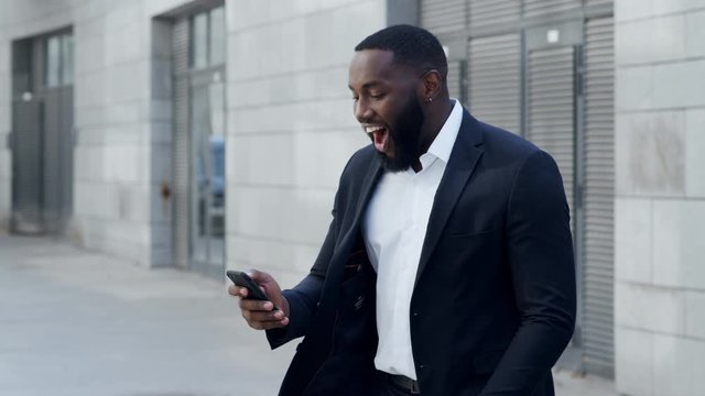Business man reading good news on cellphone. Entrepreneur celebrating victory