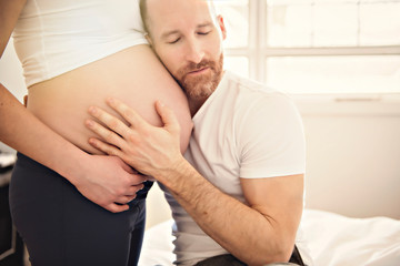 husband on the baby room at home with pregnant woman belly