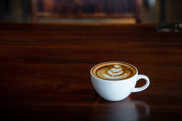 Digital tablet and cup of coffee on old wooden desk. / selective focus