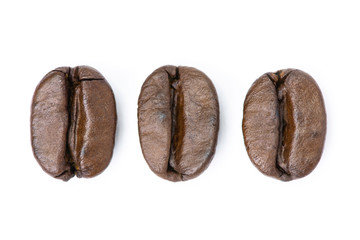 Three roasted coffee beans isolated on white background. Top view.