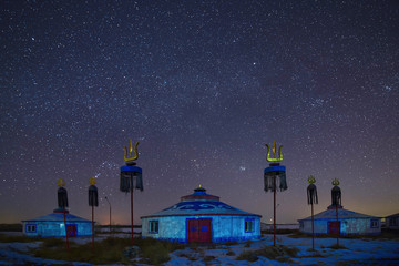 Mongolian yurts on the grassland in winter starry sky.