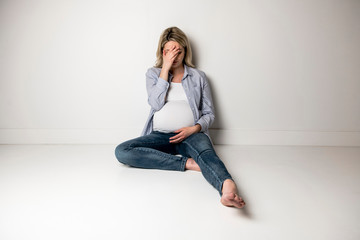 Pregnant woman with a lot of stress on white background